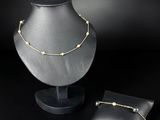 a necklace and a pillow on a black background