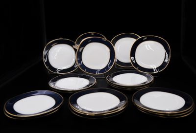 six assiettes bleues et blanches à bord doré sur fond noir