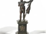une statue représentant un homme tenant un drapeau, posée sur un socle