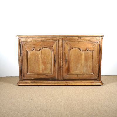 une vieille armoire en bois posée sur un sol recouvert de moquette