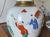 a white vase with a painting on it sitting on a table