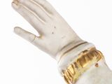 statue of a woman ' s hand with a gold bracelet on it