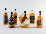 several bottles of different types of alcohol lined up on a white surface