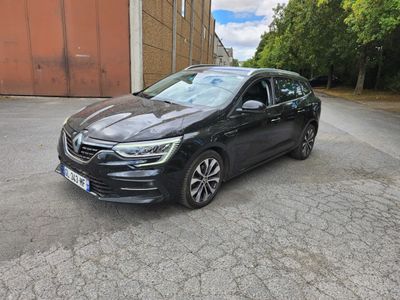une voiture noire garée dans un parking à côté d'un bâtiment