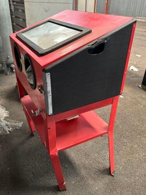 une petite armoire rouge avec un plateau en verre, posée sur un pied