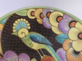 a colorful plate with a bird on it on a table