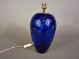 a blue glass lamp that is on a table