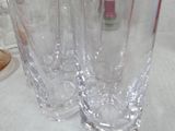four glasses sitting on a table with a bottle in the background
