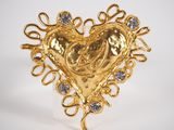 a close up of a gold heart shaped brooch with diamonds