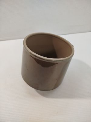 une tasse marron posée sur une table blanche