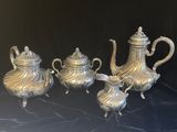 un ensemble de théières et de cafetières en argent posées sur une table