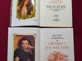 Trois livres sont posés sur une table recouverte d'une nappe rouge.