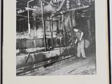 photographie en noir et blanc d'un homme travaillant sur une machine dans une usine