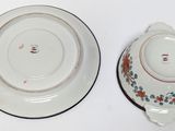 two plates and a saucer on a white table