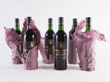 three bottles of wine sitting next to each other on a white surface