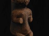 une statue en bois représentant un homme tenant un bébé dans ses bras