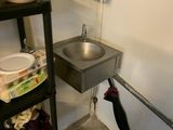 une photo d'une salle de bains avec un lavabo et une poubelle