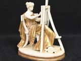 an image of a figurine of a woman sitting on a chair
