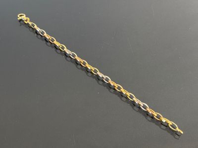 a close up of a gold chain bracelet on a black surface