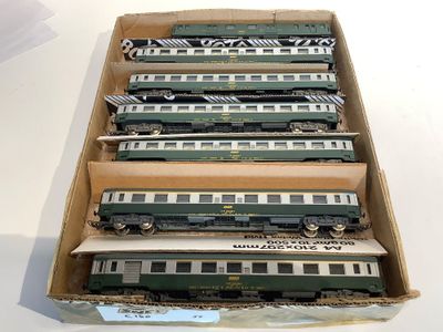 six green and white train cars in a cardboard box on a table