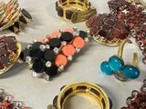 many different colored rings and bracelets on a table