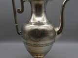 an antique silver tea pot with a bird on top of it
