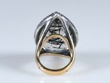 a close up of a silver and gold ring on a white surface