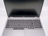 a silver laptop with a black keyboard on a white surface