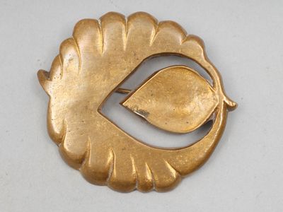 une image représentant une broche en or ornée d'une feuille