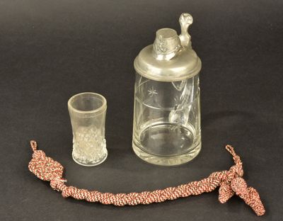 a glass jar with a bird on it next to a glass cup