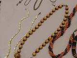 many necklaces and bracelets laid out on a table