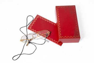 une petite boîte rouge sur laquelle est posée une paire de lunettes