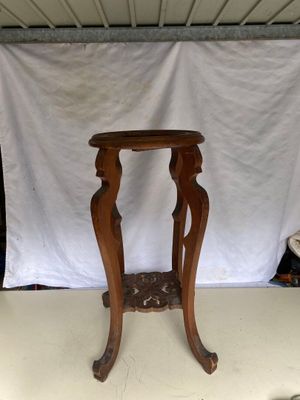 une petite table en bois avec un fond blanc derrière