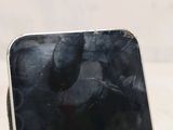 a cell phone with a broken screen sitting on a table