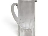 a clear glass pitcher with a handle on a white surface