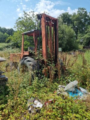 un chariot élévateur qui se trouve au milieu d'un champ