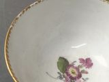 a small bowl with flowers on it sitting on a table