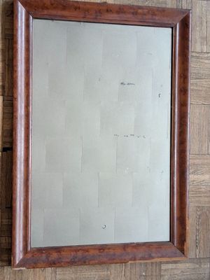 un miroir accroché au mur, avec un cadre en bois