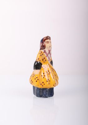 a small figurine of a woman in a yellow dress