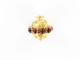 un gros plan d'une bague plaquée or ornée de perles rouges et noires