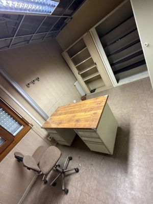 un bureau avec une chaise et une bibliothèque dans un coin