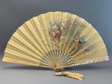 un vieux ventilateur orné d'un oiseau, posé sur une table