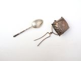 two spoons and a spoon rest on a white surface