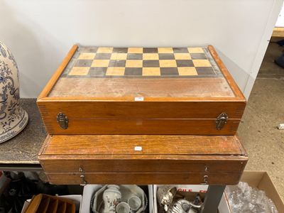 une boîte en bois sur laquelle est posé un échiquier