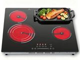 a black and red stove top with a pan of food on it
