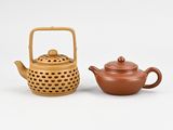 a brown teapot and a brown teapot sitting next to each other