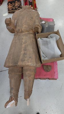 une statue en bois représentant une femme tenant une boîte