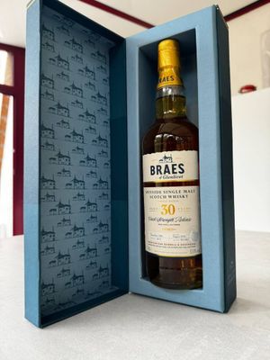 an open box with a bottle of whisky in it sitting on a table