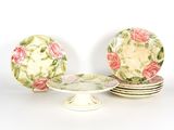 trois assiettes et un présentoir à gâteaux posés sur une table blanche