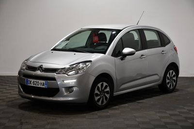 la petite voiture argentée est garée sur un sol en damier